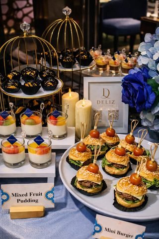 Canapé table with mini burgers and fruit puddings